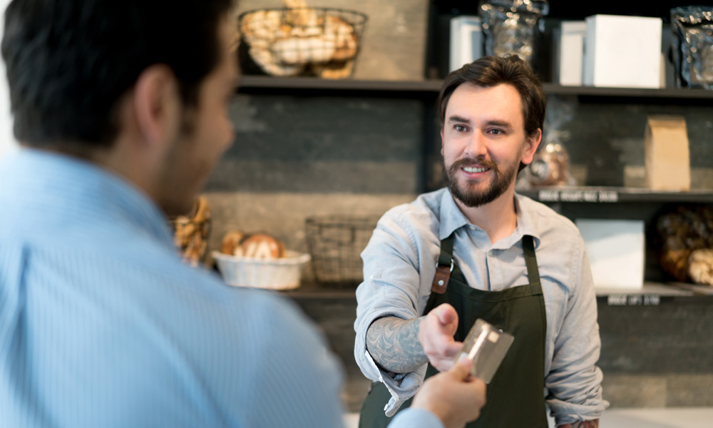 Man making a payment with a debit or credit card in a bakery
